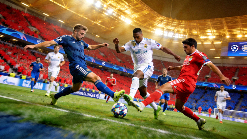 欧冠联赛半决赛激烈比赛现场画面，球员争抢足球瞬间